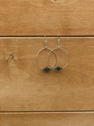 Silver hoop earrings with beads on a wooden surface