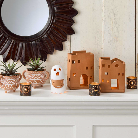 Decorative items including a ghost, candle holders, and small buildings on a mantelpiece.