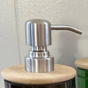 glass bottles with wooden and metallic pump tops on a wooden surface.