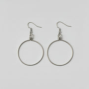 Pair of silver hoop earrings on a light gray background