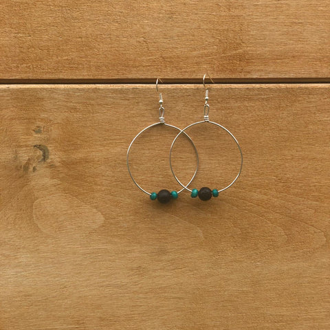 Silver hoop earrings with beads on a wooden surface
