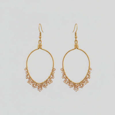 Gold hoop earring with small beads worn by a person