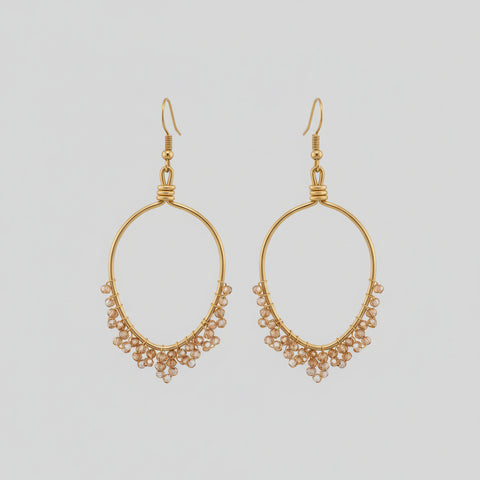 Gold hoop earring with small beads worn by a person