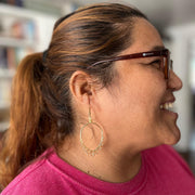 Woman wearing glasses and a pink shirt with a blurred background