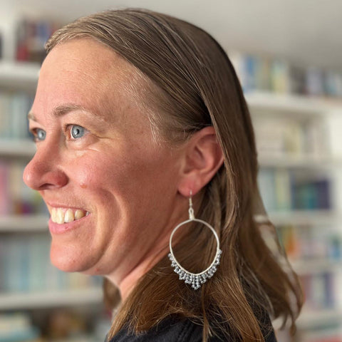 Woman wearing a silver hoop earring in a library setting