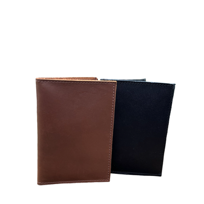 Brown and black leather wallets on a wooden surface with a blurred natural background