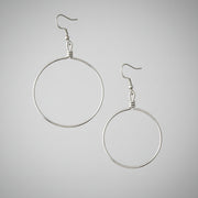 Silver hoop earrings on a gray background