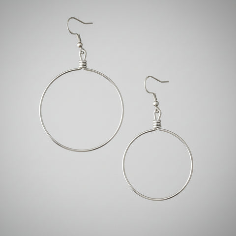 Silver hoop earrings on a gray background